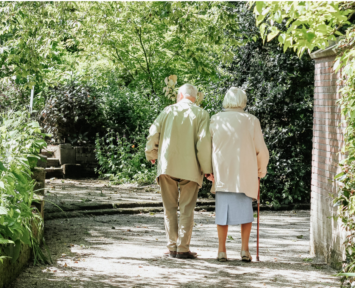 An older couple walking through a garden